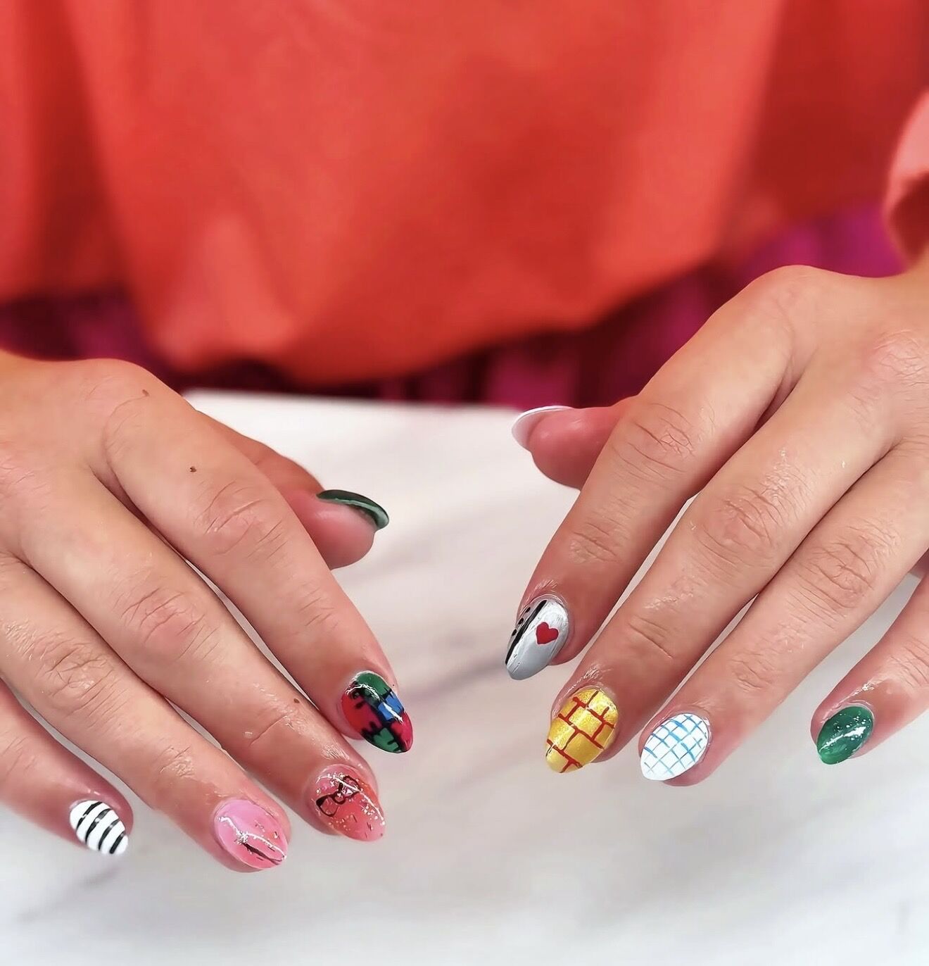 Colorful hand-painted nail art with checks, stripes and a red heart on natural nails, Lone Tree