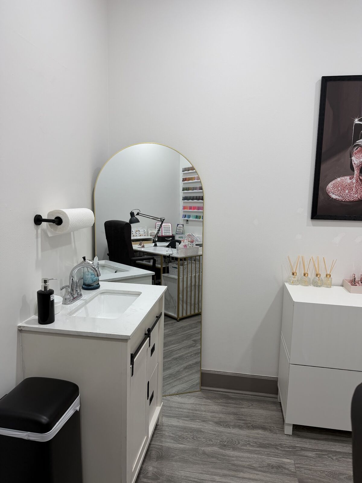 Clean hand-wash sink and arched mirror inside the private nail studio suite in Lone Tree